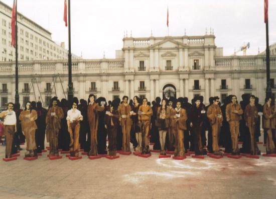 Fotografía de figuras de personas situadas frente a La Moneda